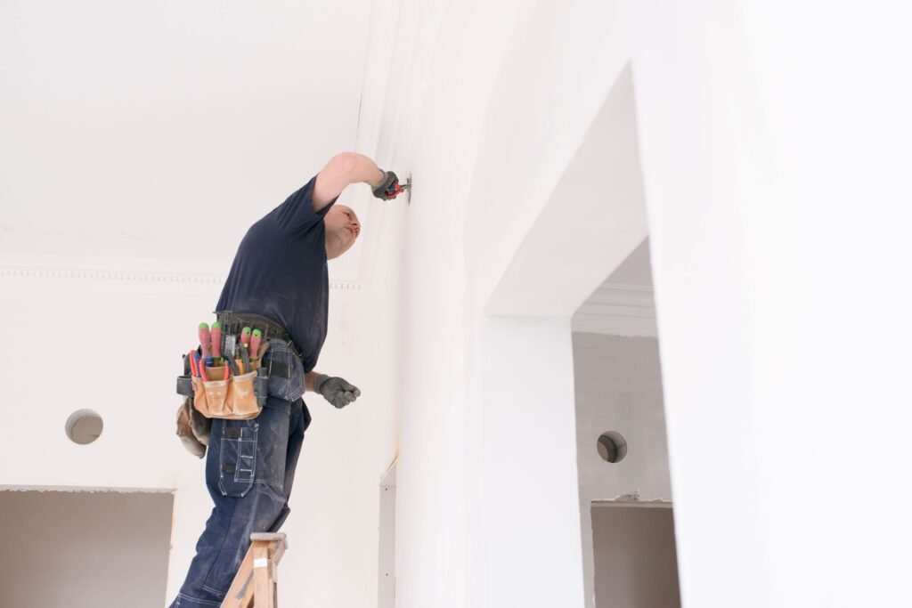 homme sur une échelle qui fait des travaux dans un appartement